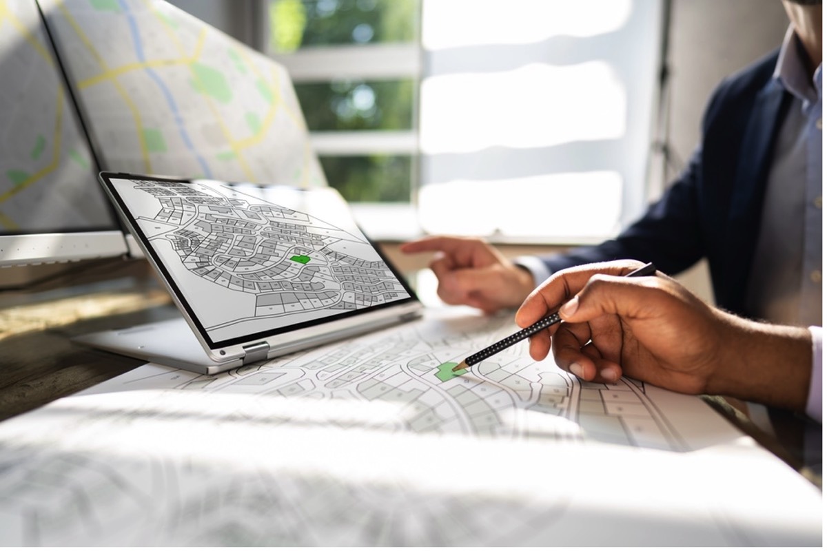 surveyor comparing digital and paper survey plans